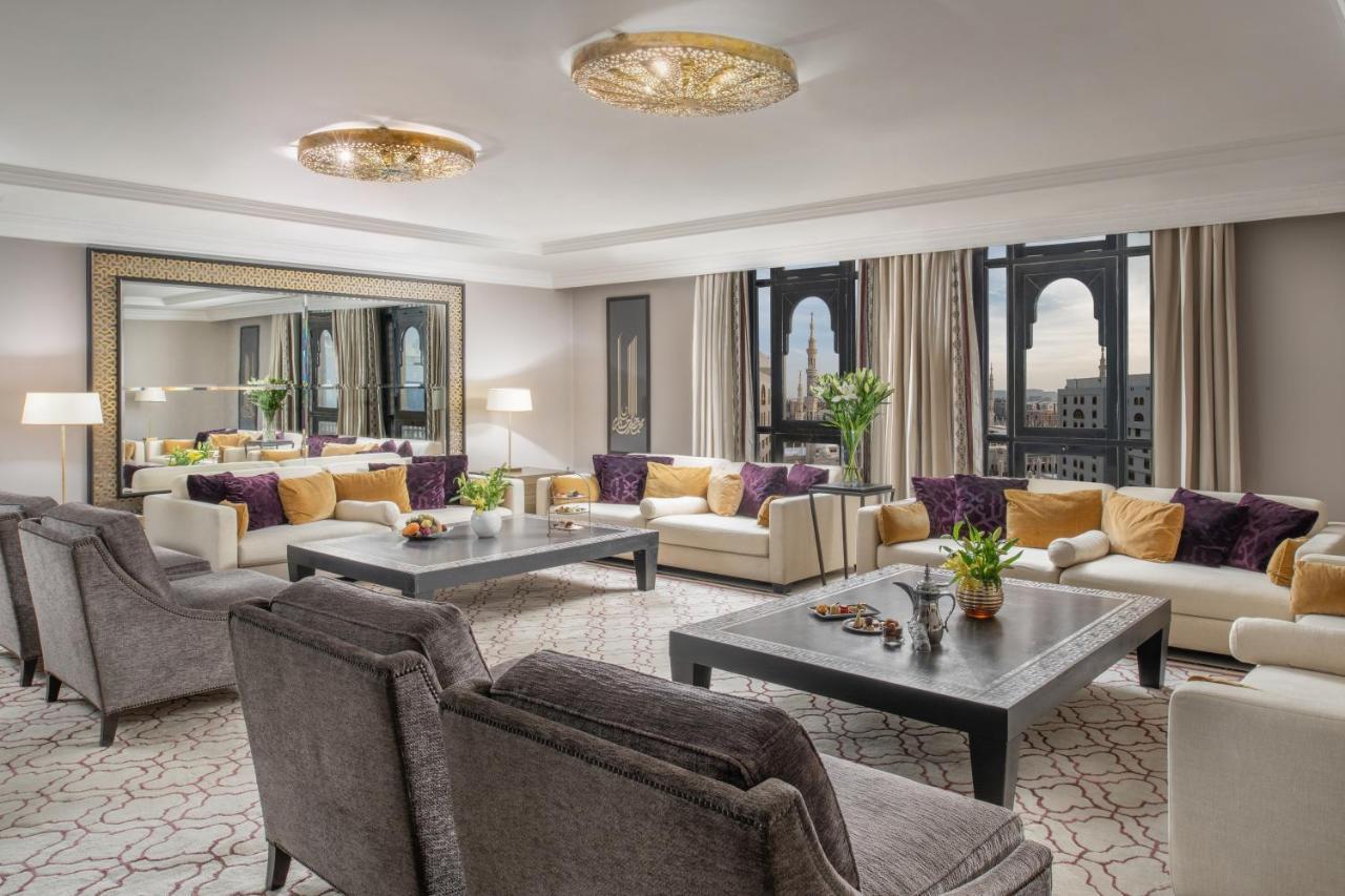 Sofitel Shahd Al Madinah Otel Medine Dış mekan fotoğraf The photo shows a luxurious living room space. It features elegant furniture, including plush sofas with a mix of light and dark tones, and decorative cushions. A large coffee table sits in the center, adorned with a small plant and decorative items.