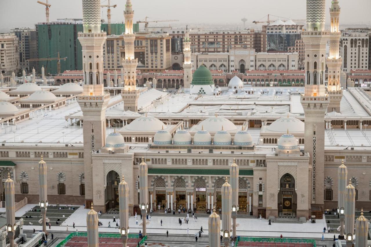 Sofitel Shahd Al Madinah Otel Medine Dış mekan fotoğraf The photo shows an aerial view of a mosque complex, with prominent architectural features such as tall minarets and a large dome. The structure is notable for its intricate design and is likely surrounded by an open courtyard where people are gathere